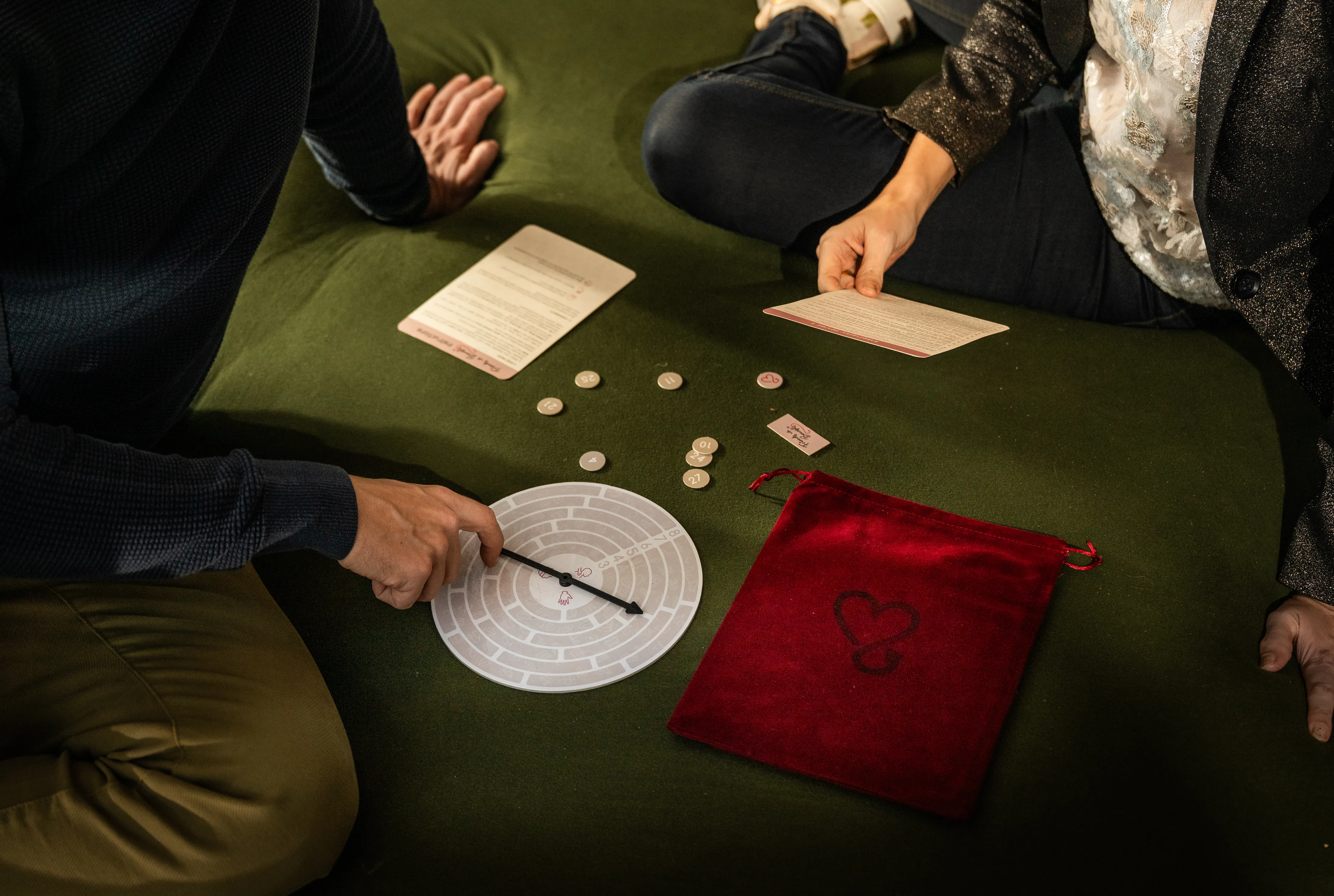 Two people playing Friends With Benefits, spinning the wheel and drawing cards